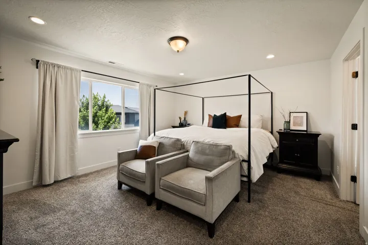 Spacious interior featuring neutral carpeting, white walls, recessed lighting, and a large window
