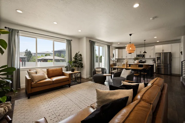 Open-concept living space featuring wood-finish flooring, recessed lighting, and large windows