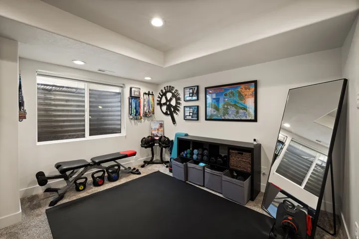 Spacious room featuring neutral carpeting, a large window with horizontal blinds, and recessed lighting