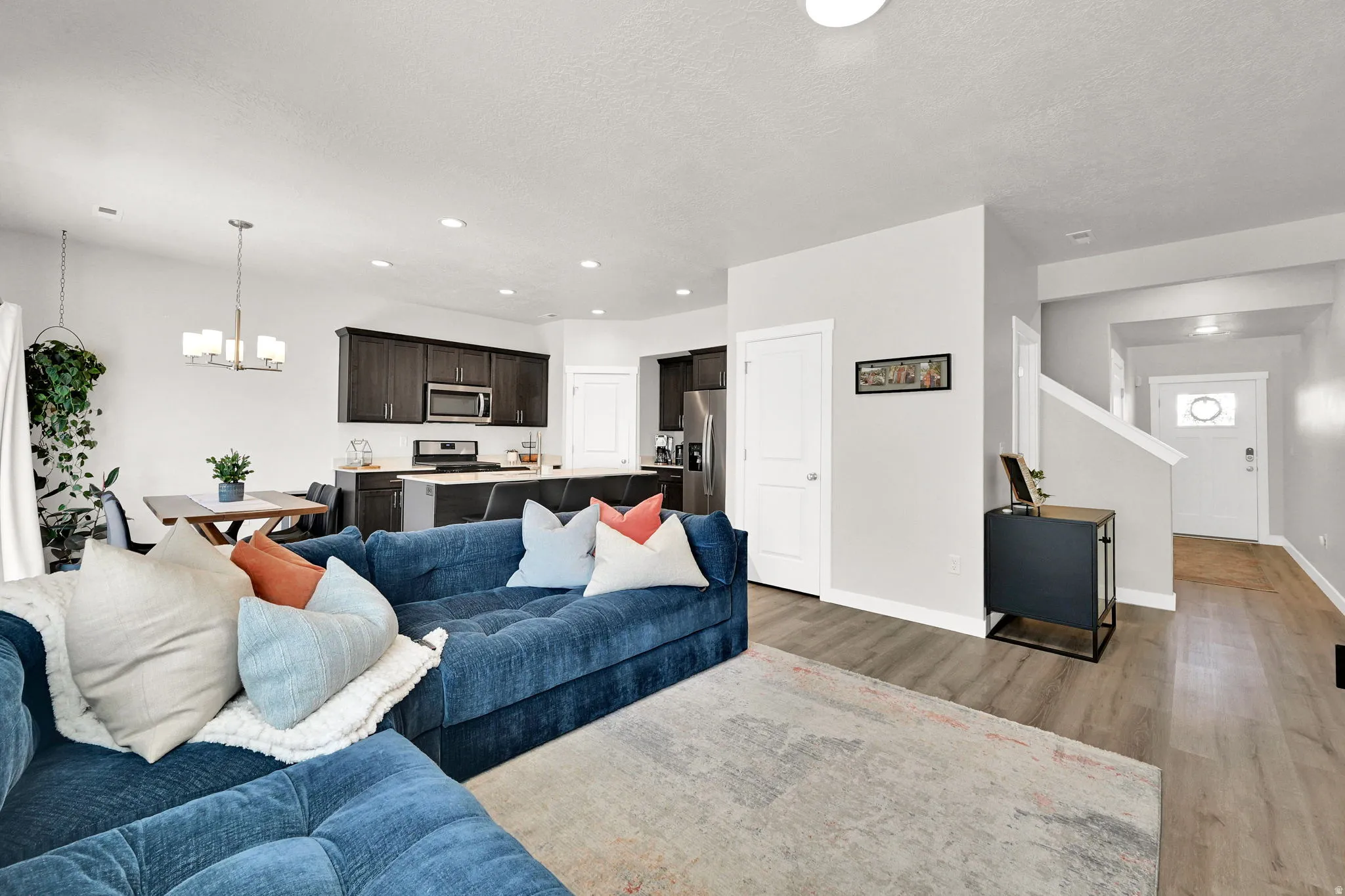 Open-concept living area featuring wood-finish flooring, recessed lighting, and a modern kitchen