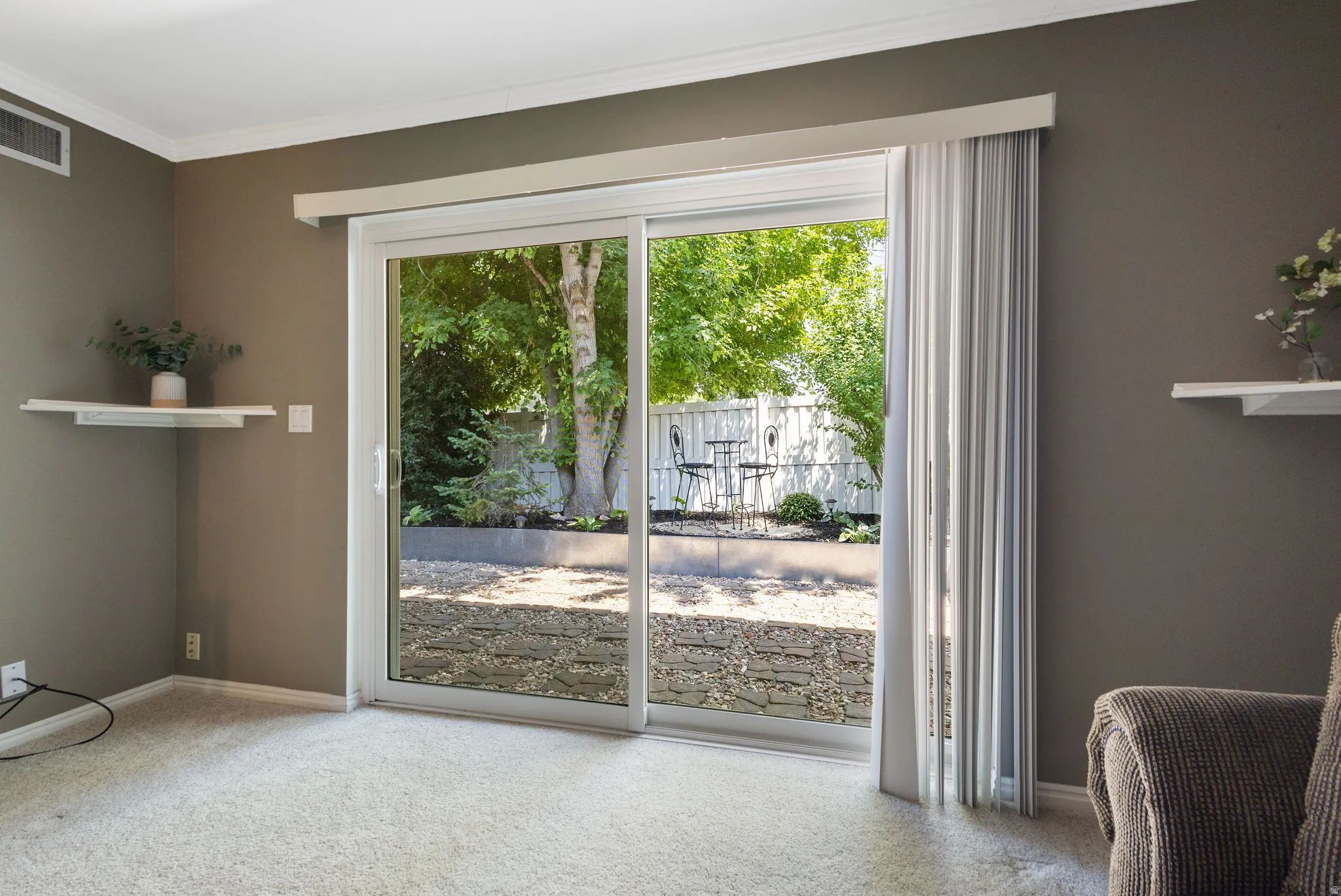 Sliding glass door opening to a landscaped backyard