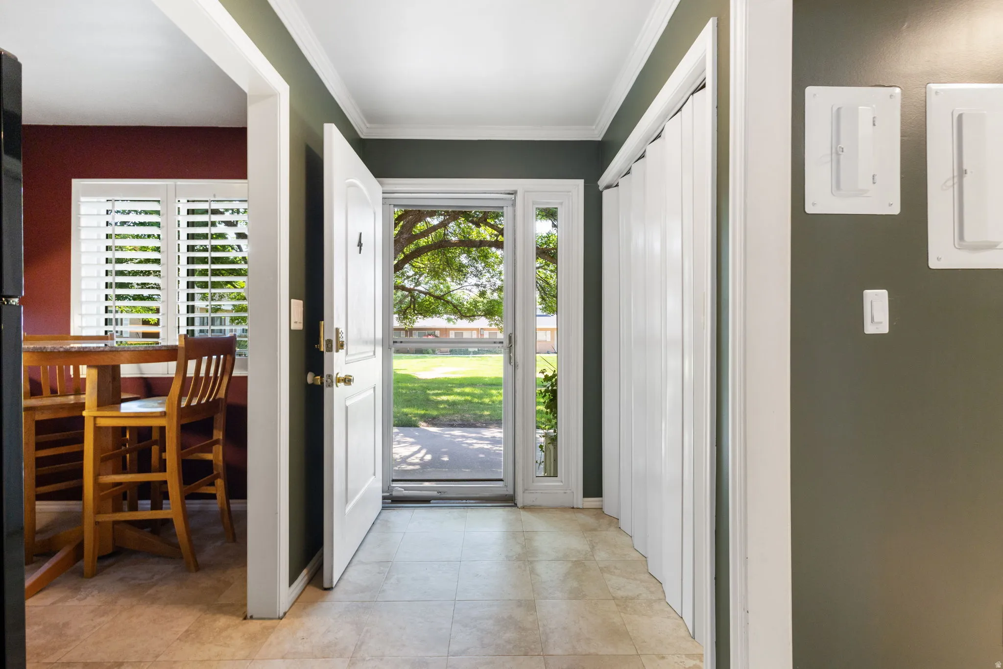 Inviting entryway with tile flooring and a white paneled front door