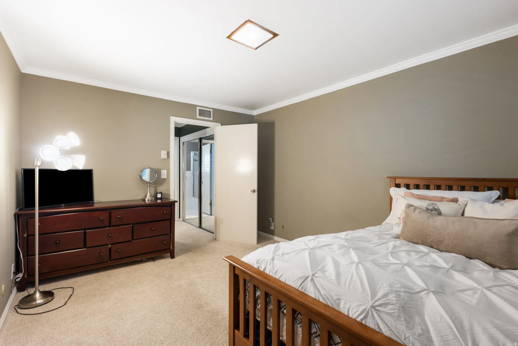 Carpeted bedroom with neutral wall tones and white crown molding
