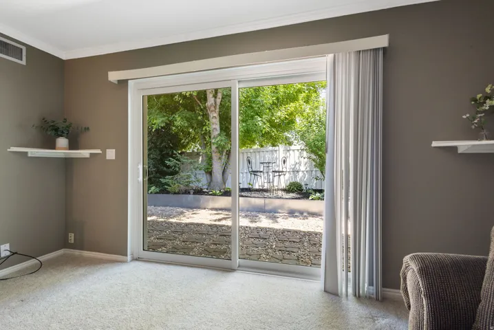 Sliding glass door opening to a landscaped backyard