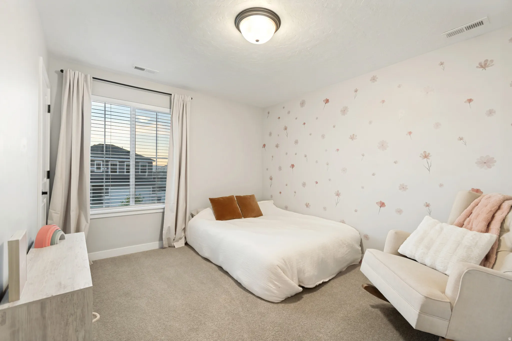 Carpeted interior space featuring a window with horizontal blinds and drapery