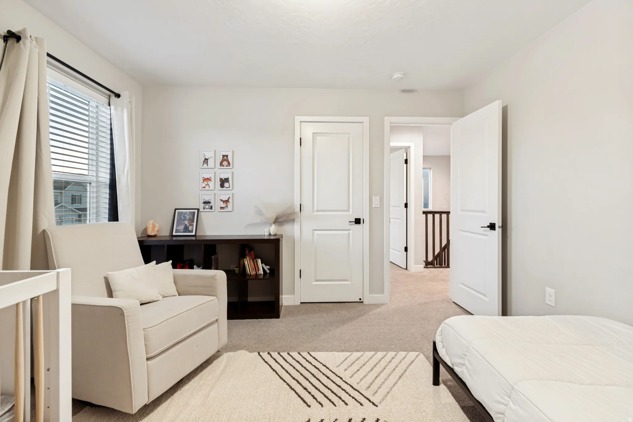 Neutral wall paint and carpeting throughout, featuring white trim and doors with black hardware