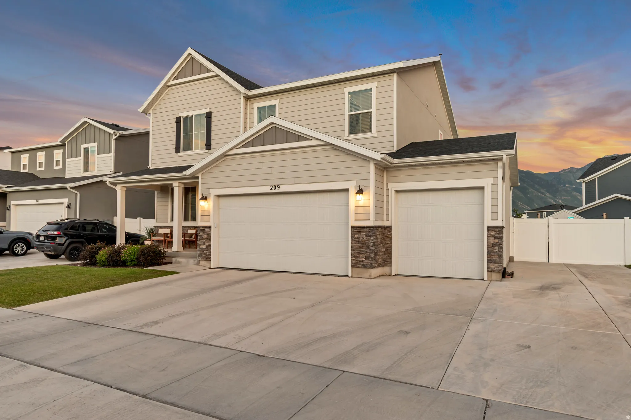 Modern suburban residence featuring light-colored siding and a two-car garage