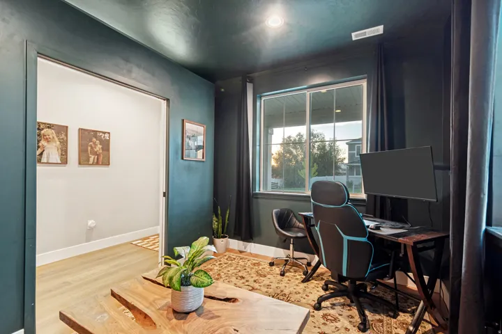 Versatile room with dark accent walls, light wood-finish flooring, and a large window