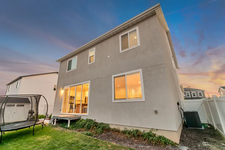 Stucco exterior featuring multiple windows and a sliding glass door