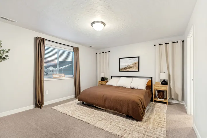 Carpeted room featuring a window with horizontal blinds, a flush mount ceiling light fixture, and white wall paint