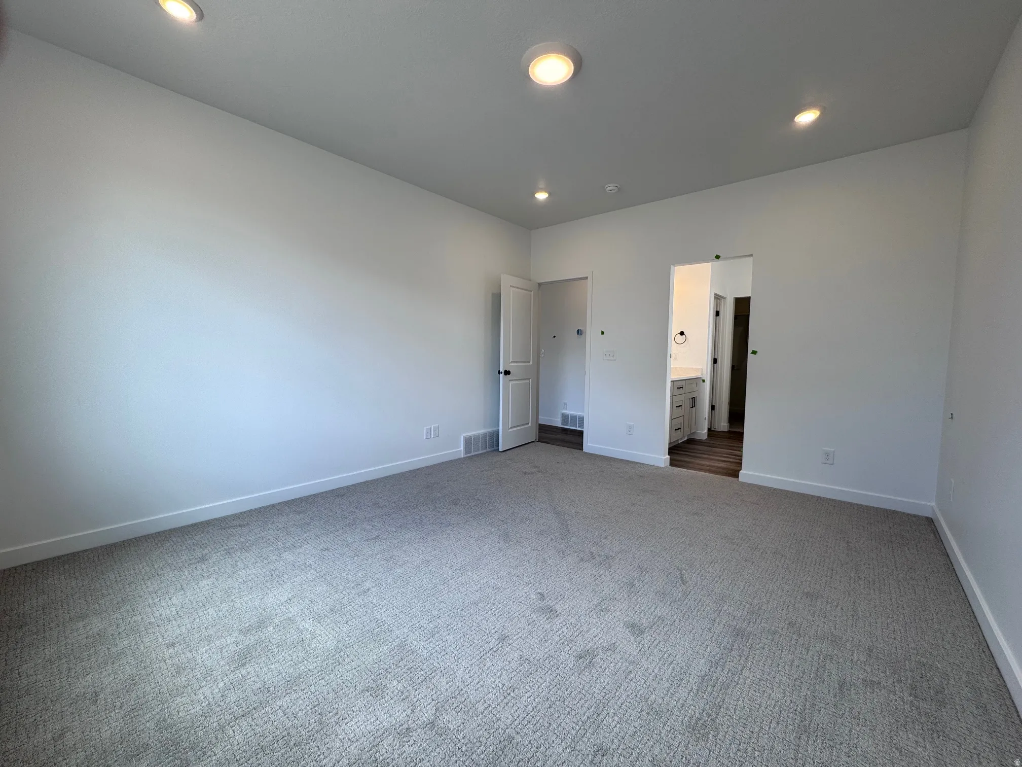 Spacious room featuring neutral carpeting and recessed lighting
