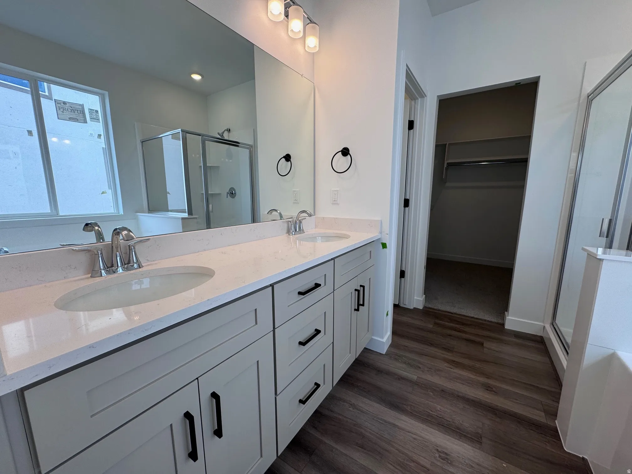 Double vanity with light-toned cabinetry, quartz countertops, and dual undermount sinks