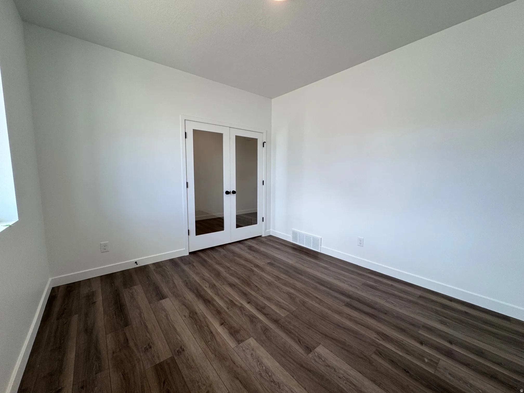 Interior space featuring wood-finish flooring, white walls, and bright white trim