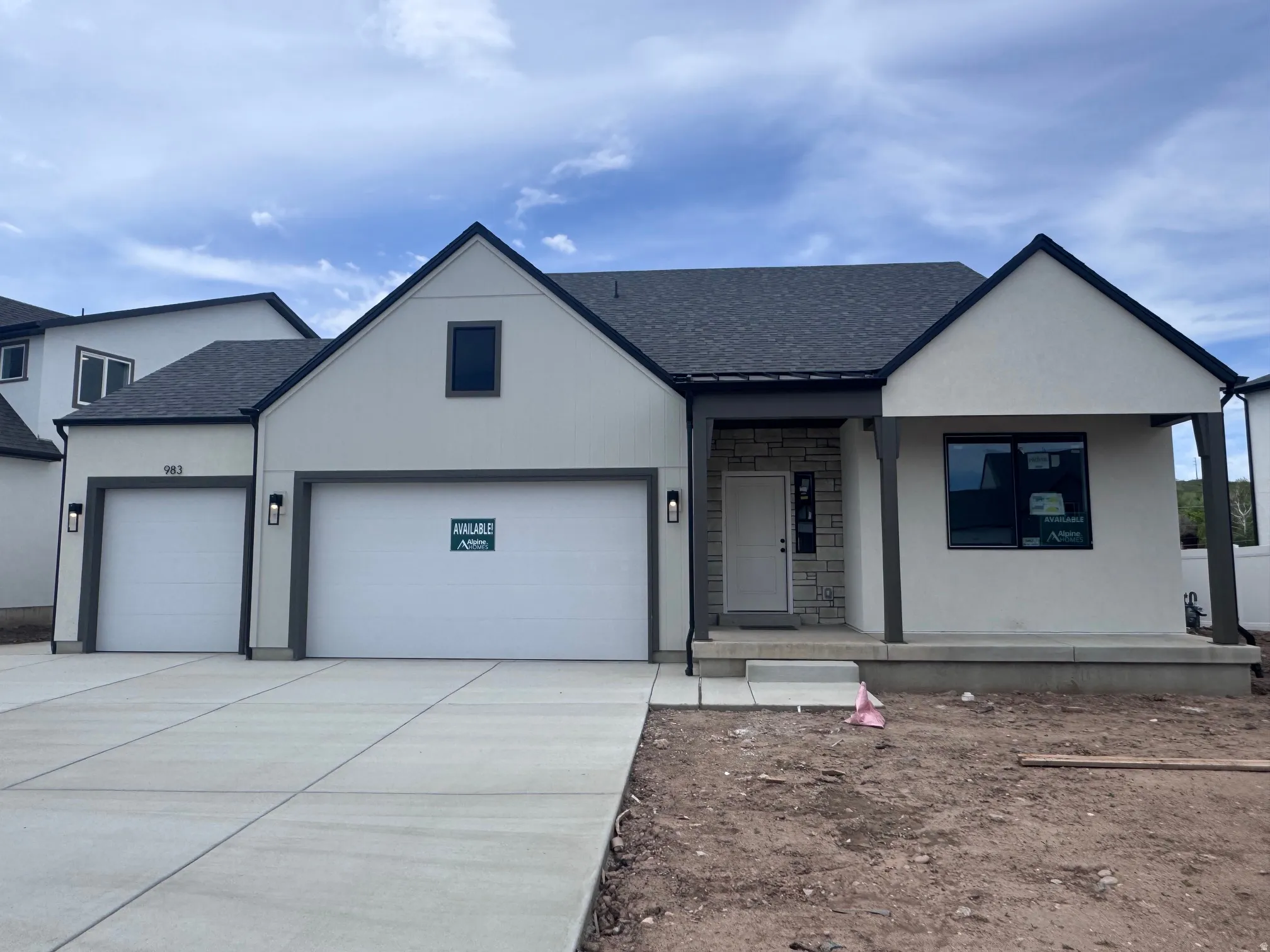 Contemporary exterior featuring white stucco, dark trim accents, and a stone facade entry
