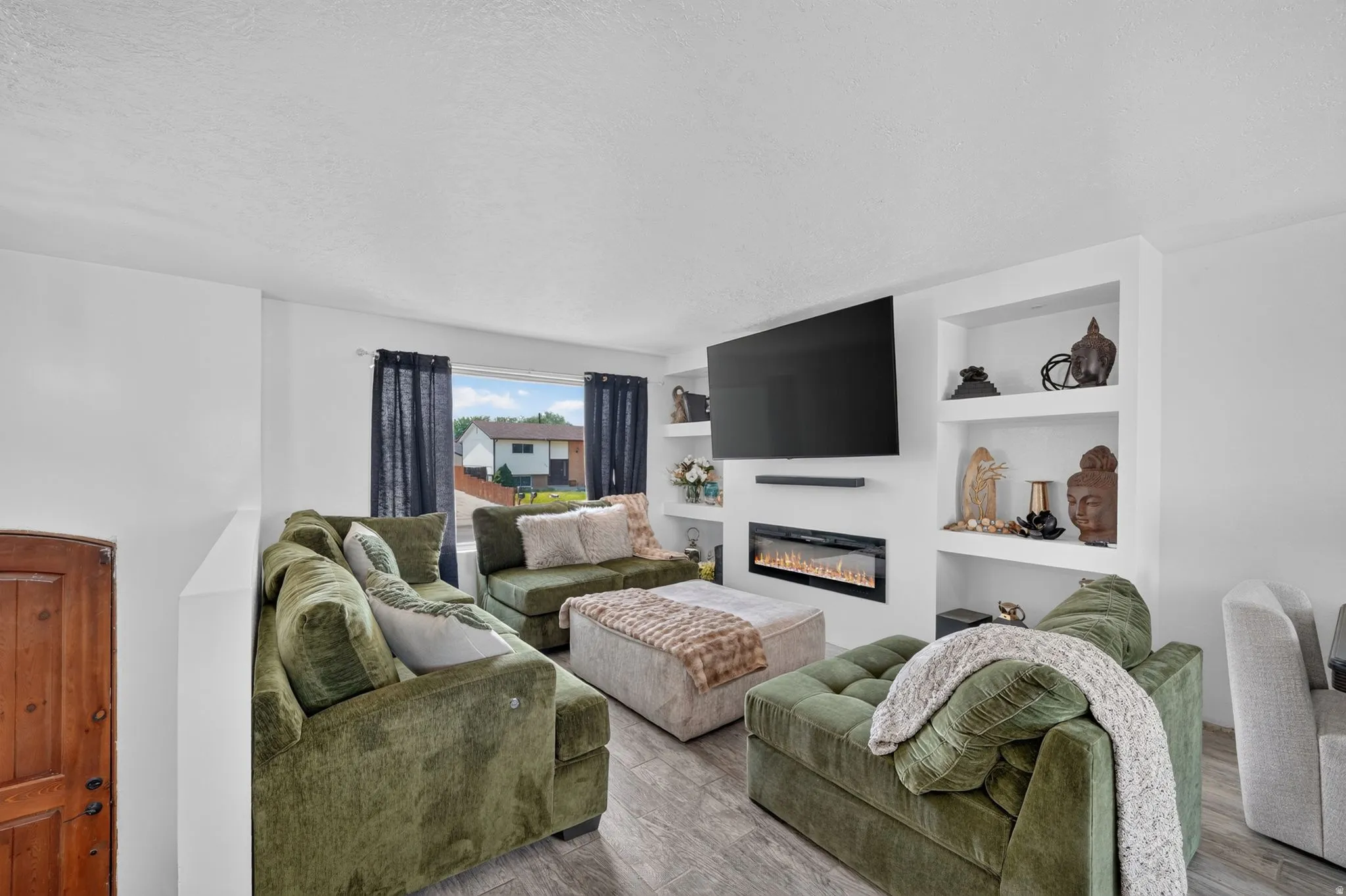 Contemporary living area featuring wood-finish flooring and a large window
