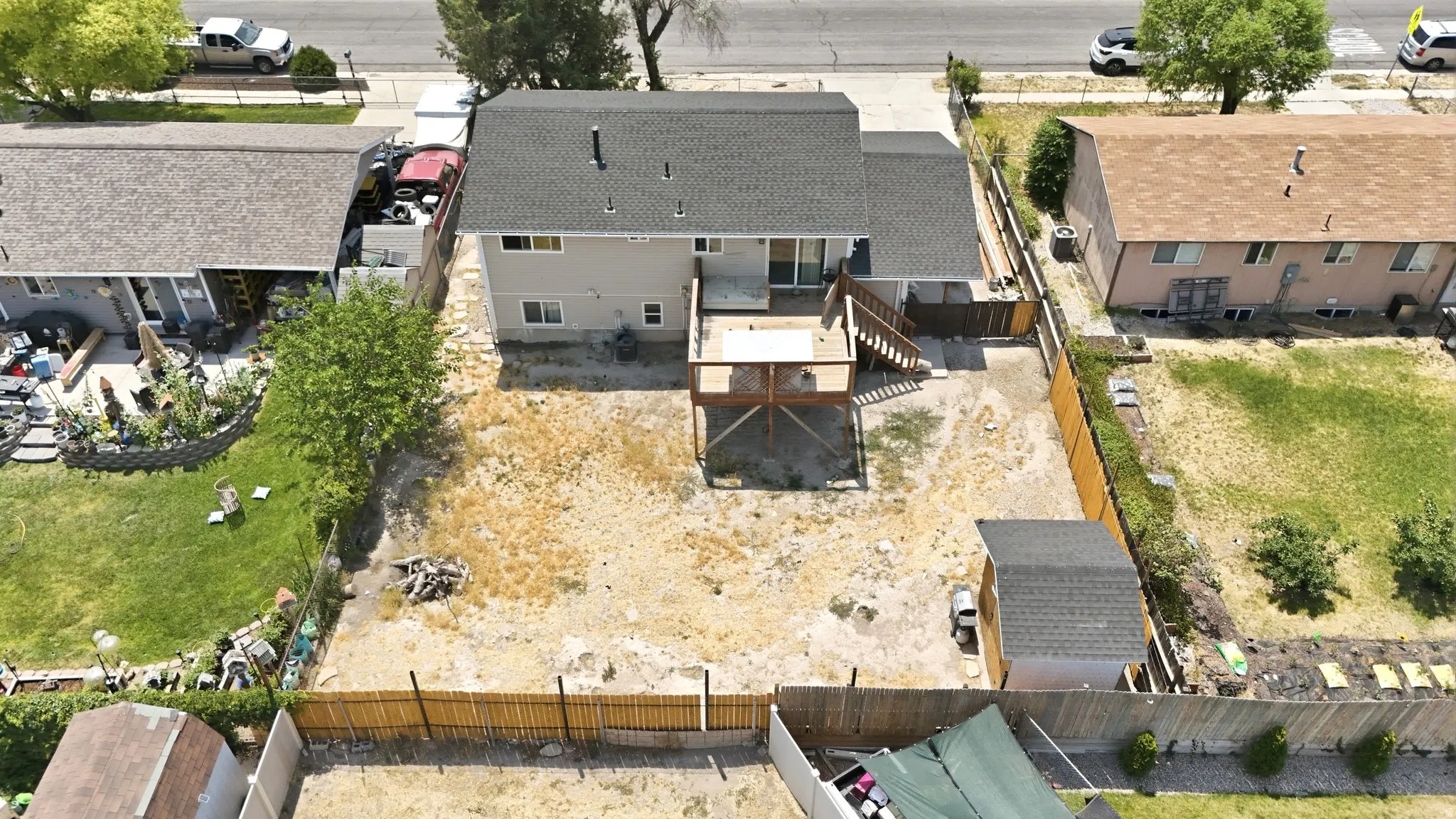 Rear exterior featuring a multi-level wooden deck, sliding glass door, and a detached shed