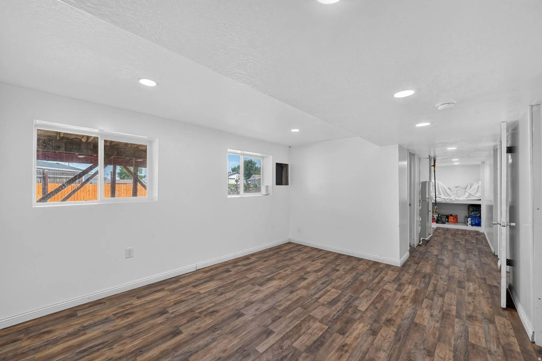 Versatile interior space featuring wood-finish flooring, recessed lighting, and white walls