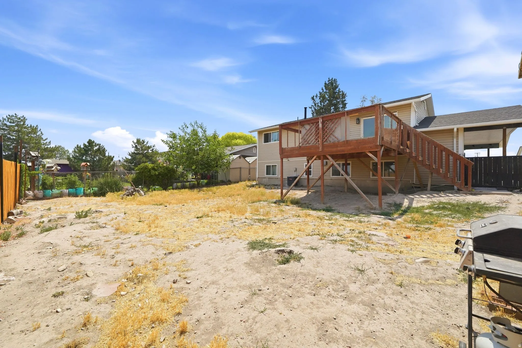 Expansive outdoor space featuring a two-story wood deck with railing, providing outdoor access from the upper level