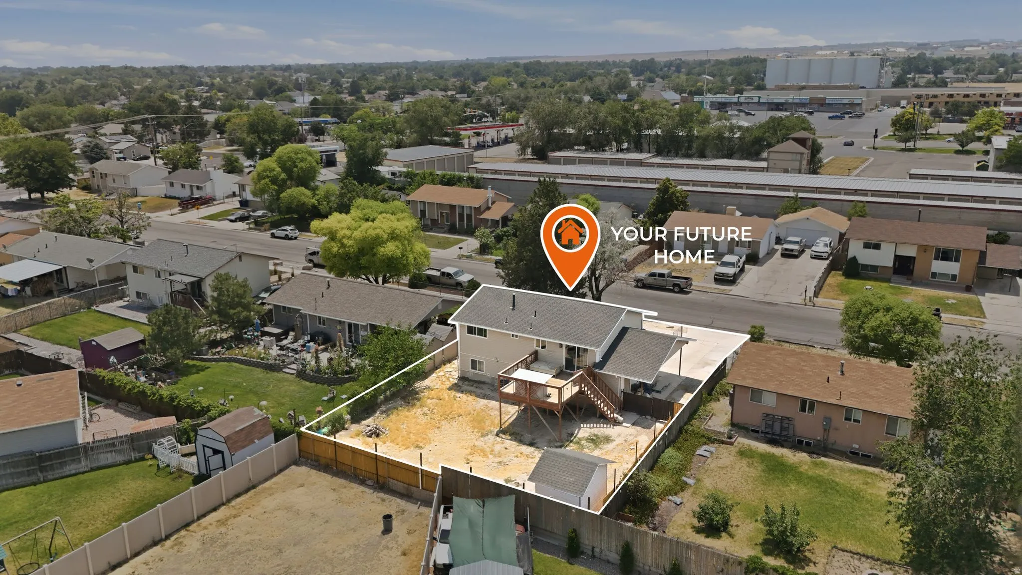 Two-story residence featuring a fenced backyard with a raised deck and a ground-level patio