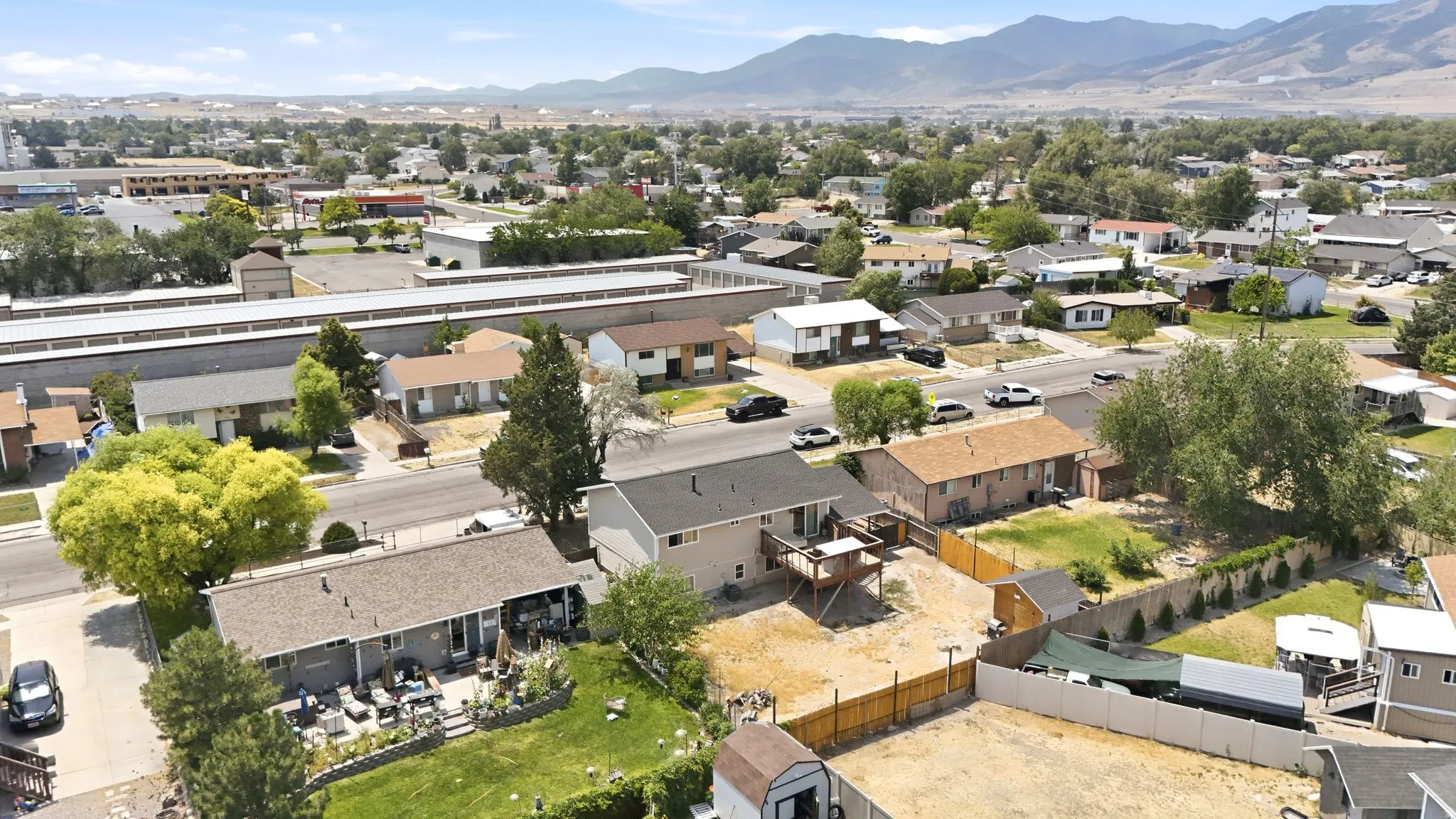 Expansive aerial showcasing a residential neighborhood with a mountain backdrop