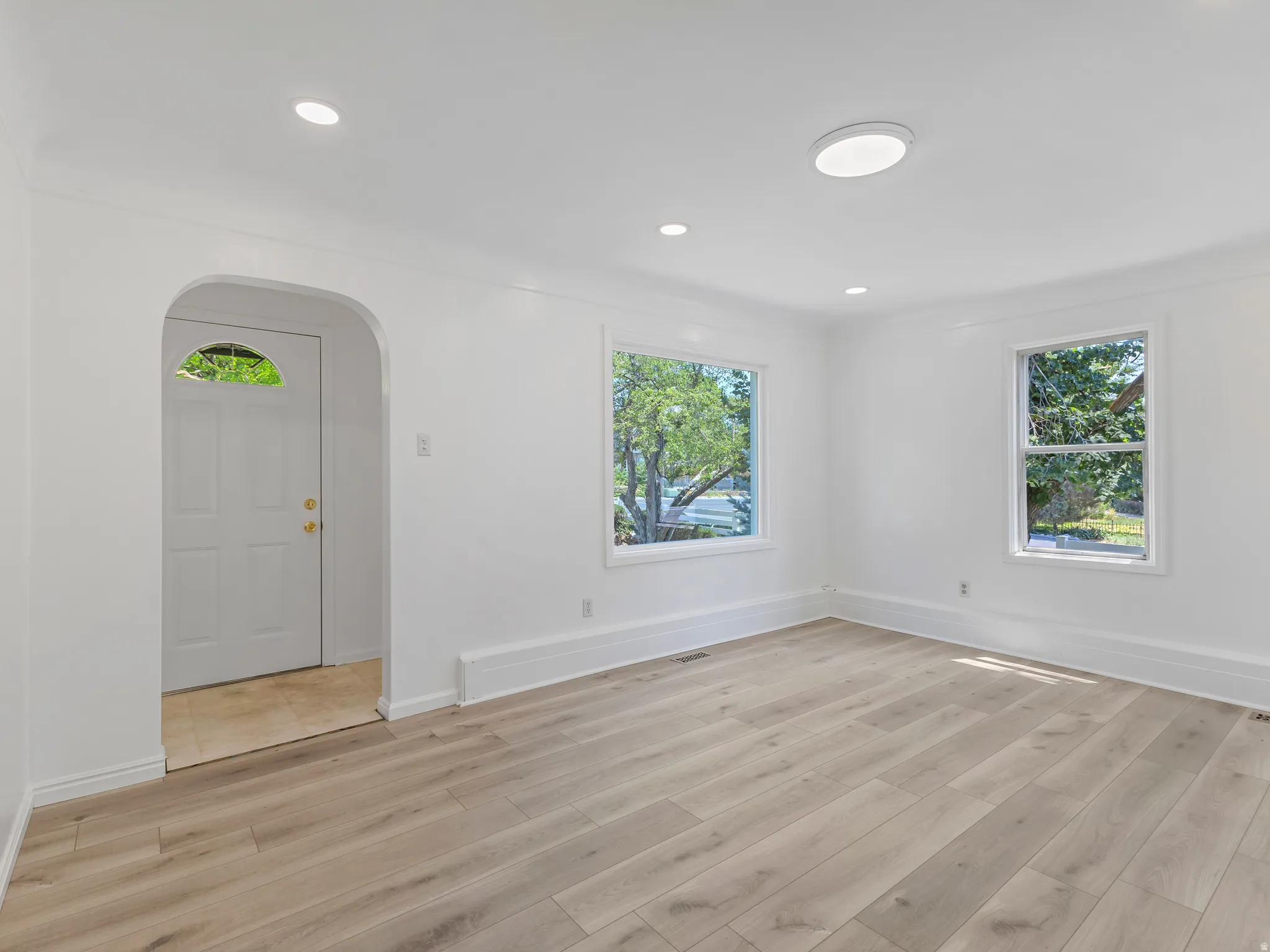 Spacious interior featuring light wood-finish flooring, white walls, and recessed lighting
