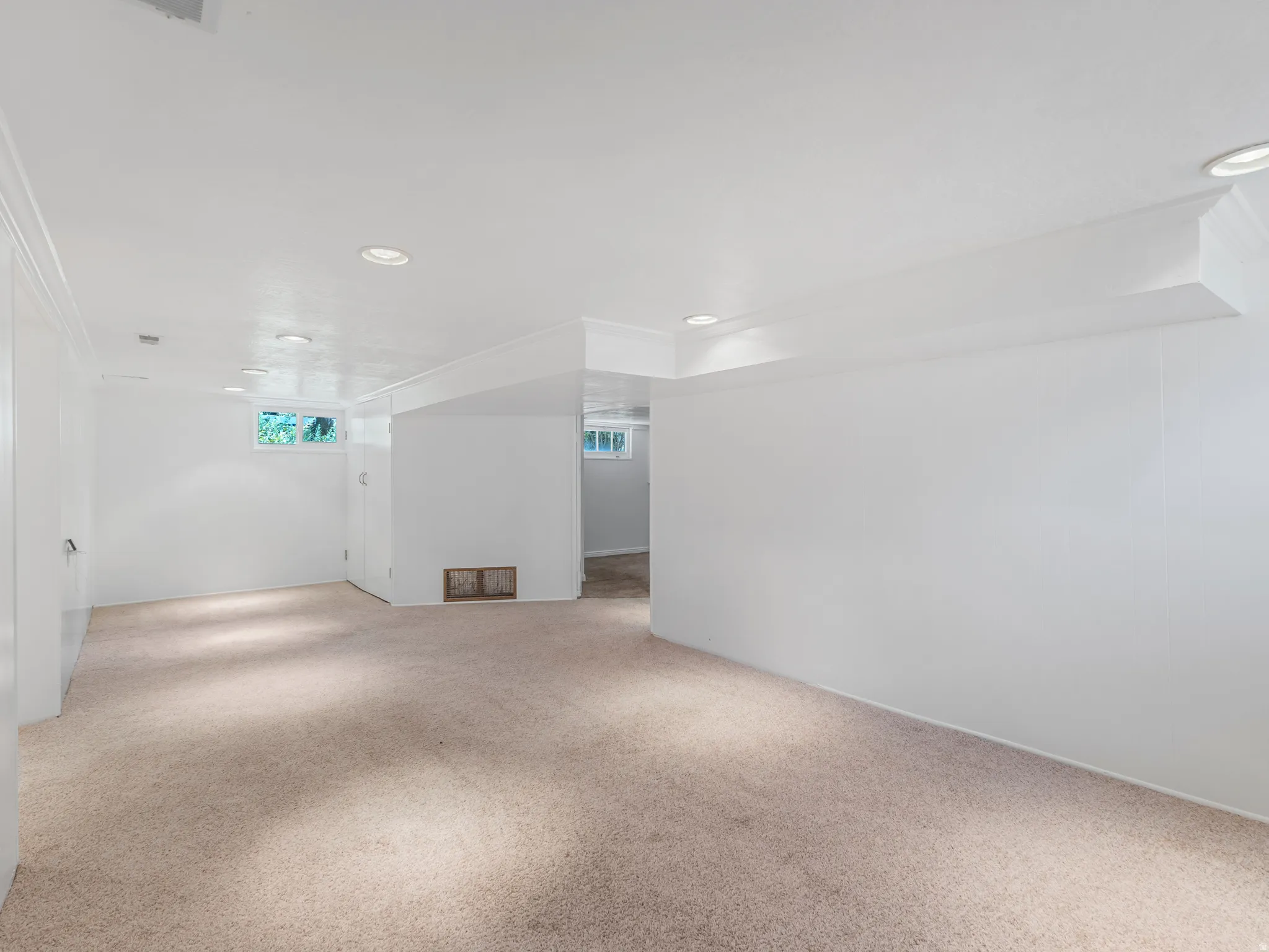 Versatile interior space featuring light-colored carpeting and white walls