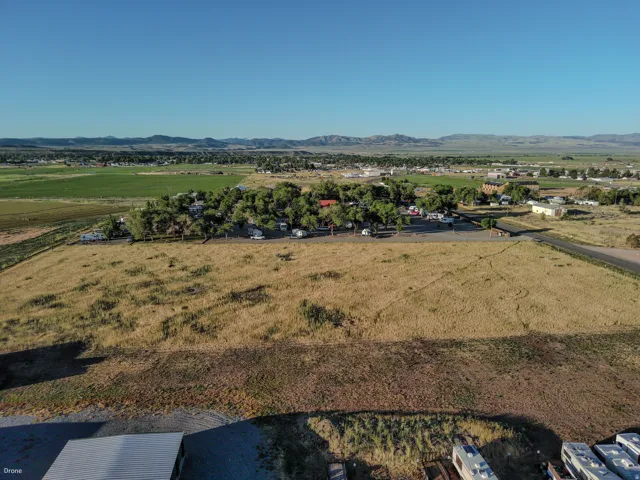 Expansive open acreage featuring varied terrain, a distant mountain range, and a clear sky backdrop