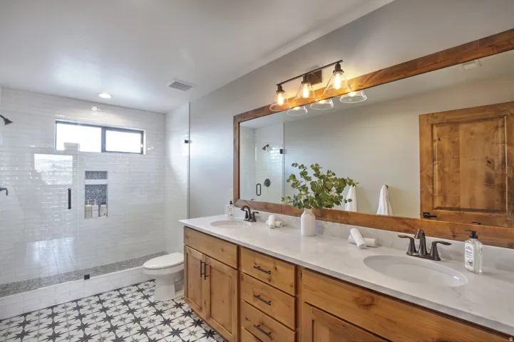 Bathroom featuring a dual vanity with wood-finish cabinetry and white countertops