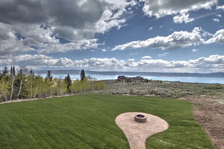 Expansive green lawn with a circular fire pit area