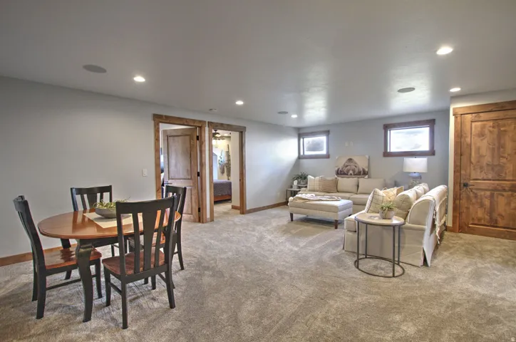 Spacious living area featuring light gray walls, recessed lighting, and soft gray carpeting