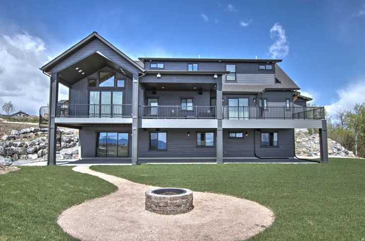 Multi-level rear exterior featuring dark gray siding and multiple balconies with dark railings