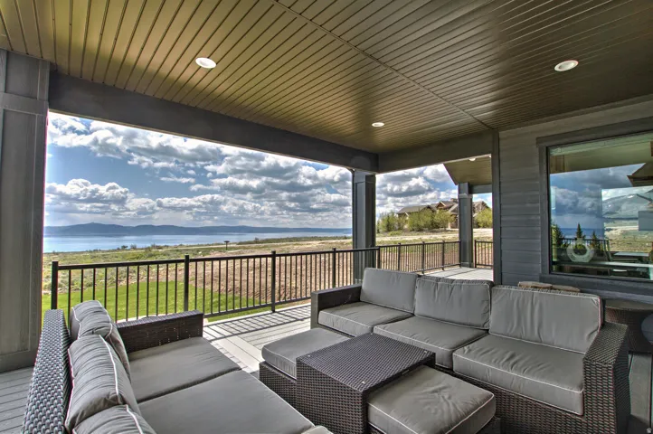 Covered patio featuring recessed lighting, a durable composite deck, and a black metal railing