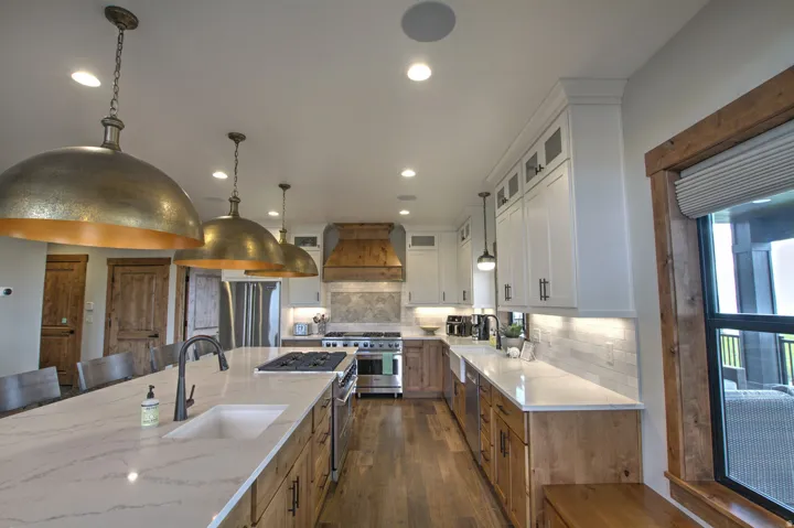 Gourmet kitchen featuring a substantial island with integrated sink, a built-in cooktop, and a matte black faucet