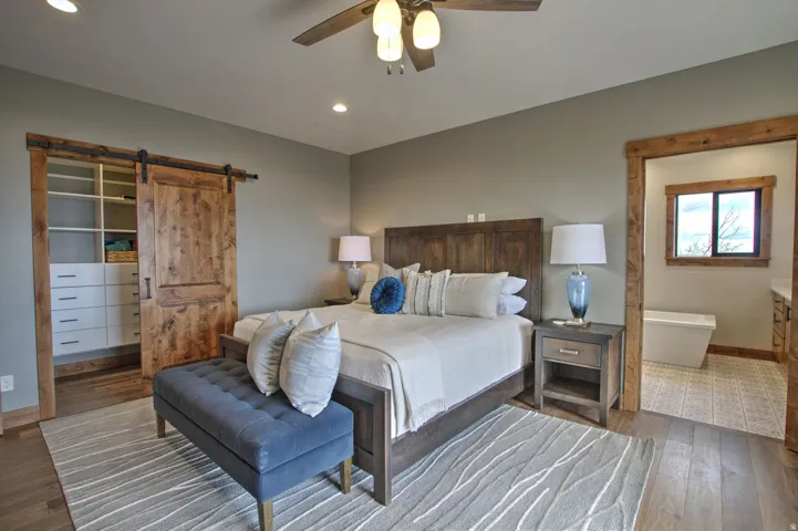 Bedroom featuring wood-finish flooring, a built-in closet with barn door entry, and recessed lighting
