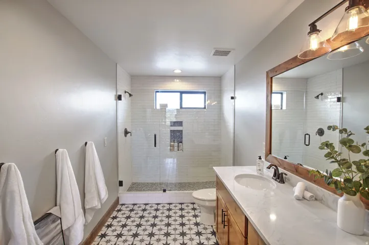 Bathroom featuring a walk-in shower with glass enclosure, subway tile surround, and built-in niche