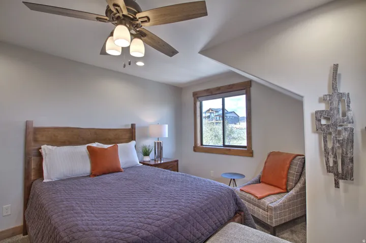 Room featuring a ceiling fan with integrated lighting, wood-framed window, recessed lighting, and a sloped ceiling detail
