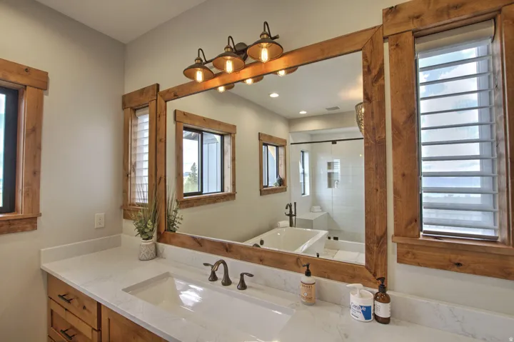 Bathroom vanity featuring a single sink with a bronze faucet, wood-finish cabinetry, and a light-toned countertop