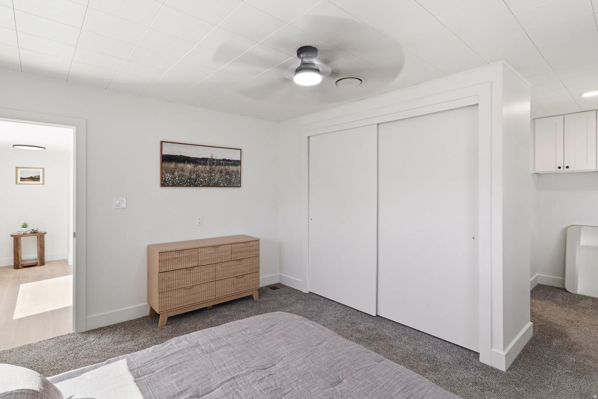 Bedroom featuring gray carpet, white walls, and a ceiling fan with integrated lighting