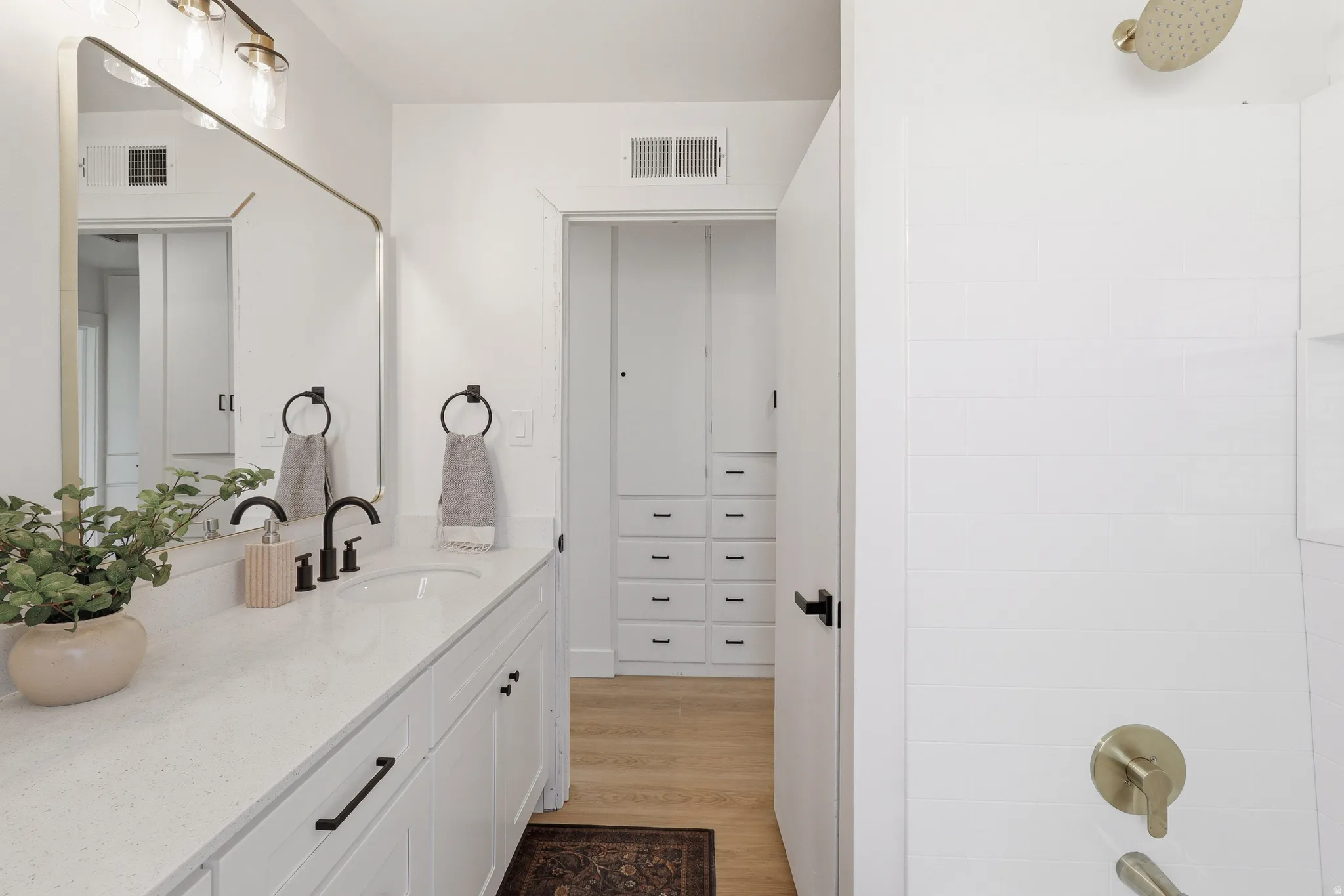 Vanity featuring a quartz countertop, integrated sink, and matte black faucet