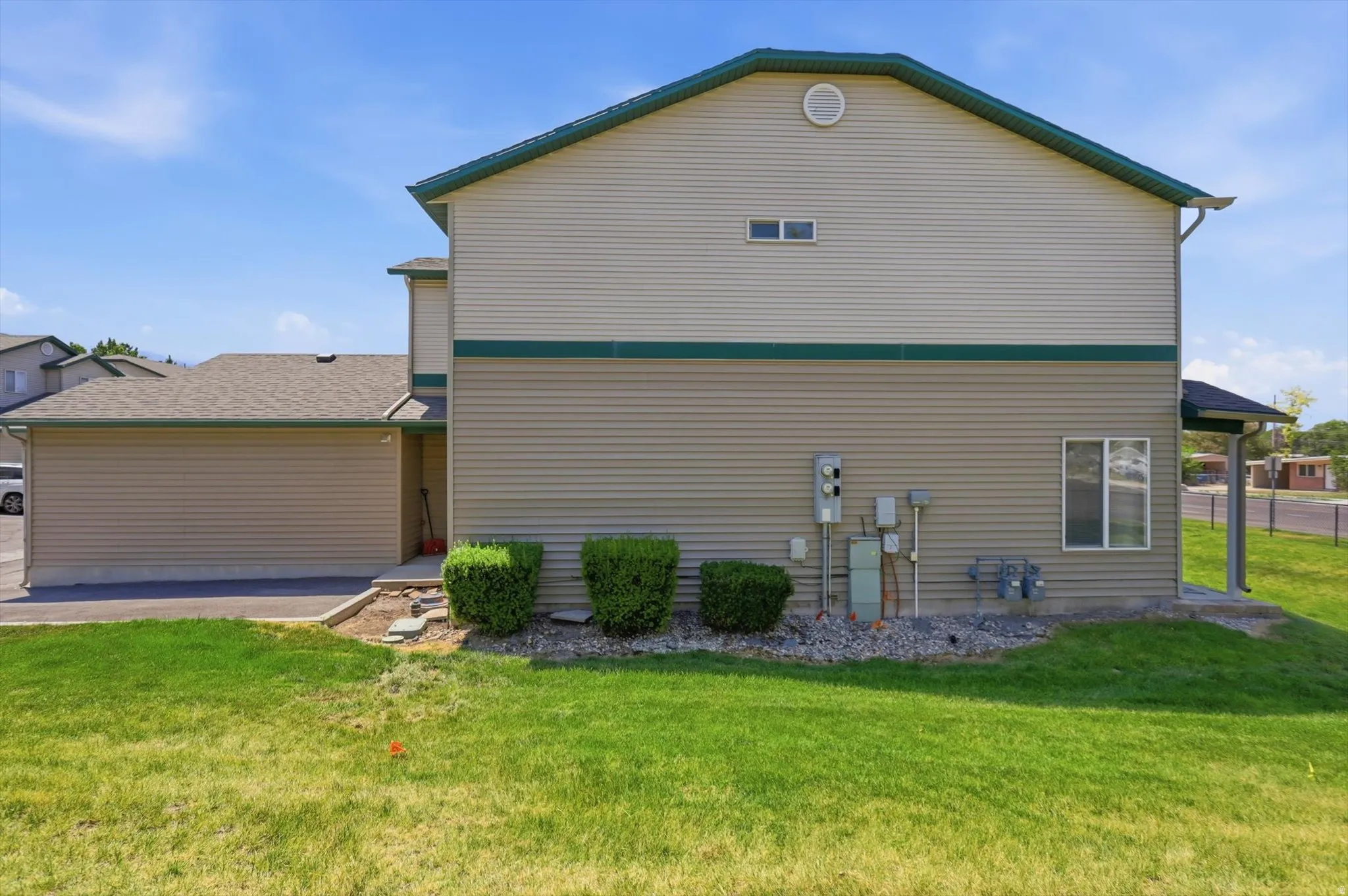 Two-story property with horizontal siding in tan and green tones