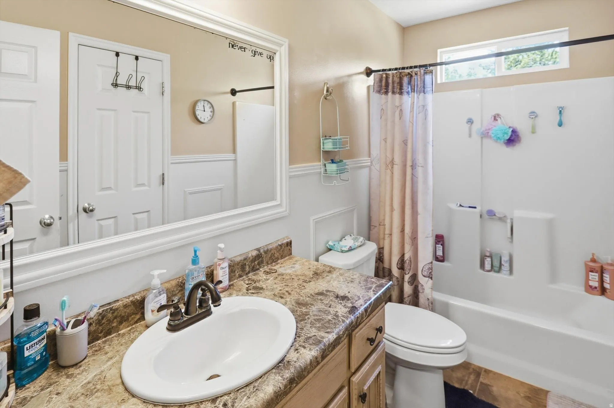 Bathroom featuring a vanity with a cultured marble countertop, an oval undermount sink, and a two-handle bronze faucet