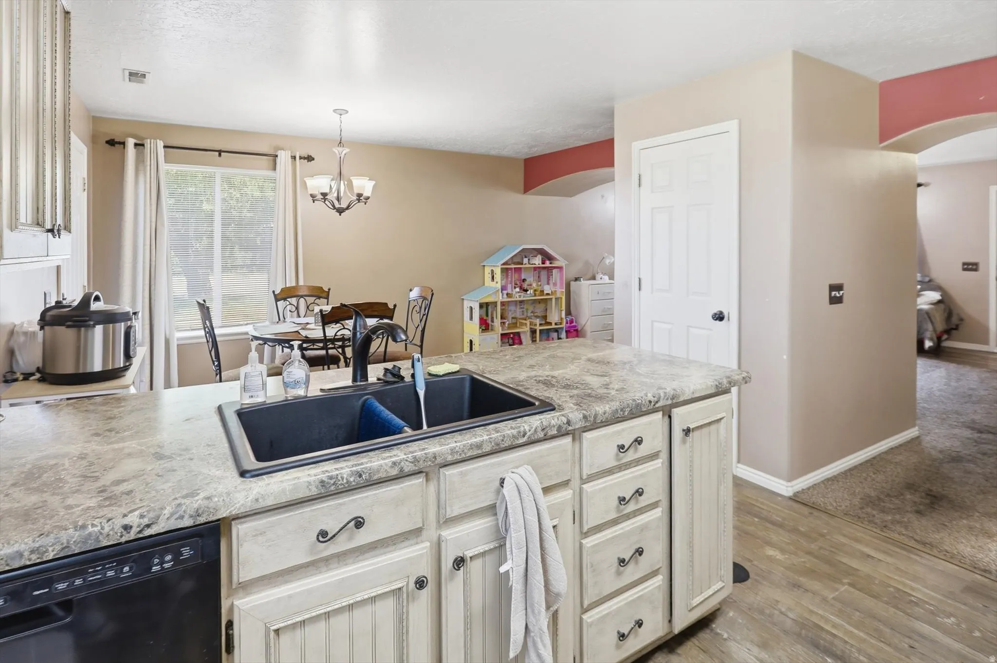 Kitchen island featuring a black composite sink with a gooseneck faucet