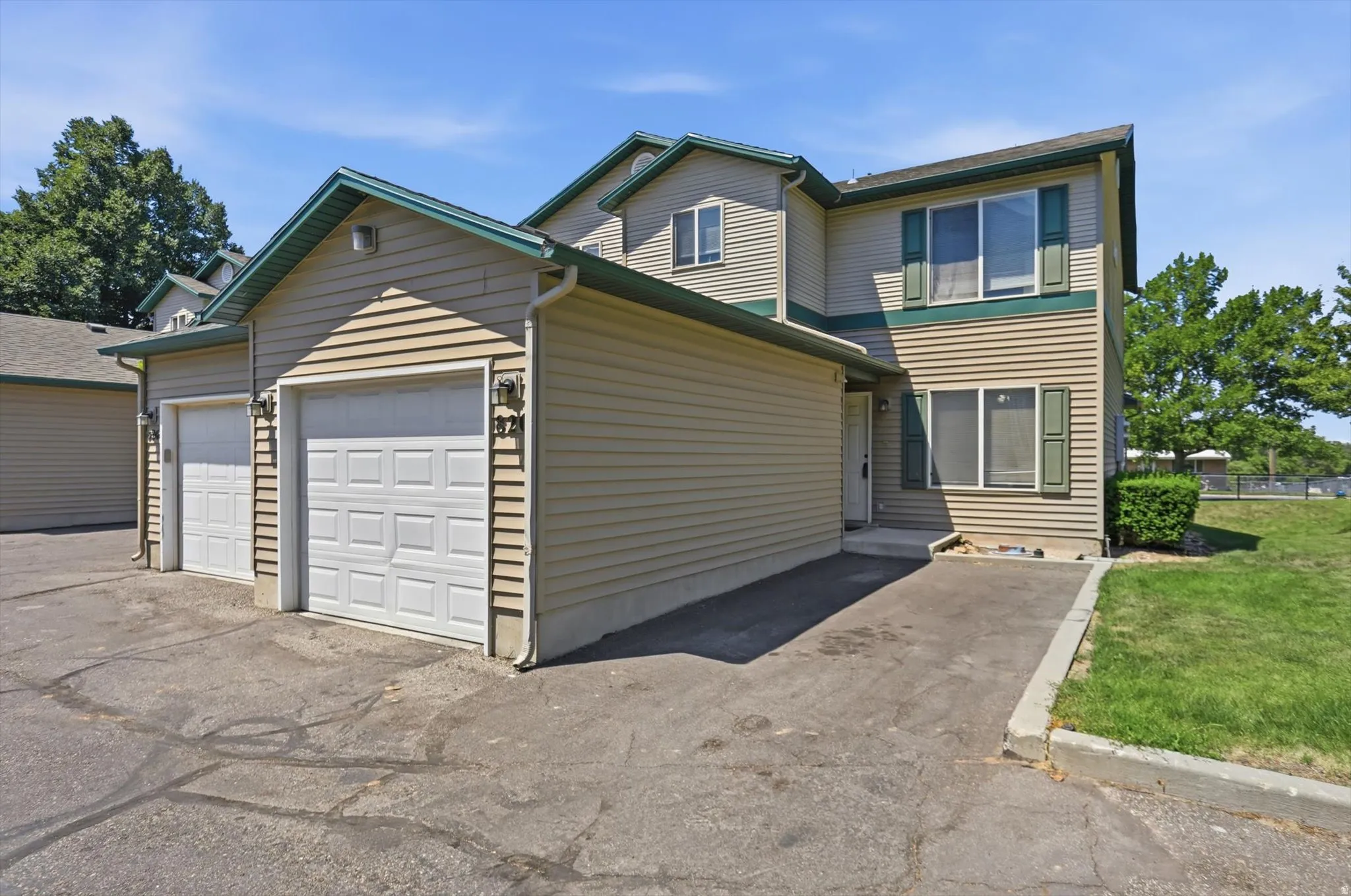 Tan siding exterior with green trim accents and multiple windows