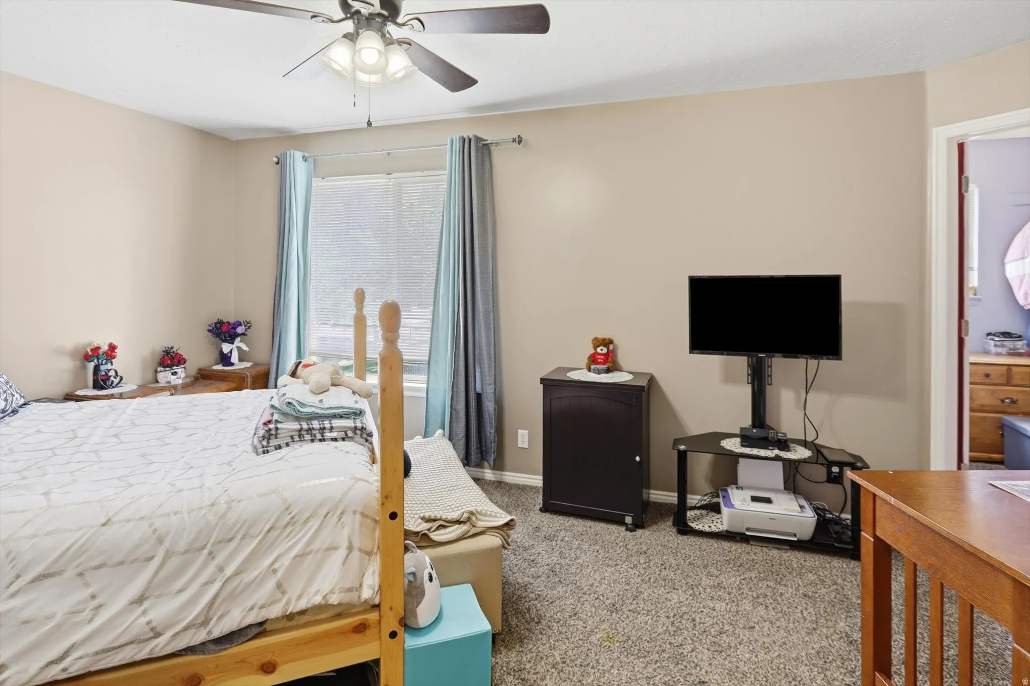 Room featuring neutral-toned walls, carpeted flooring, and a ceiling fan with integrated lighting