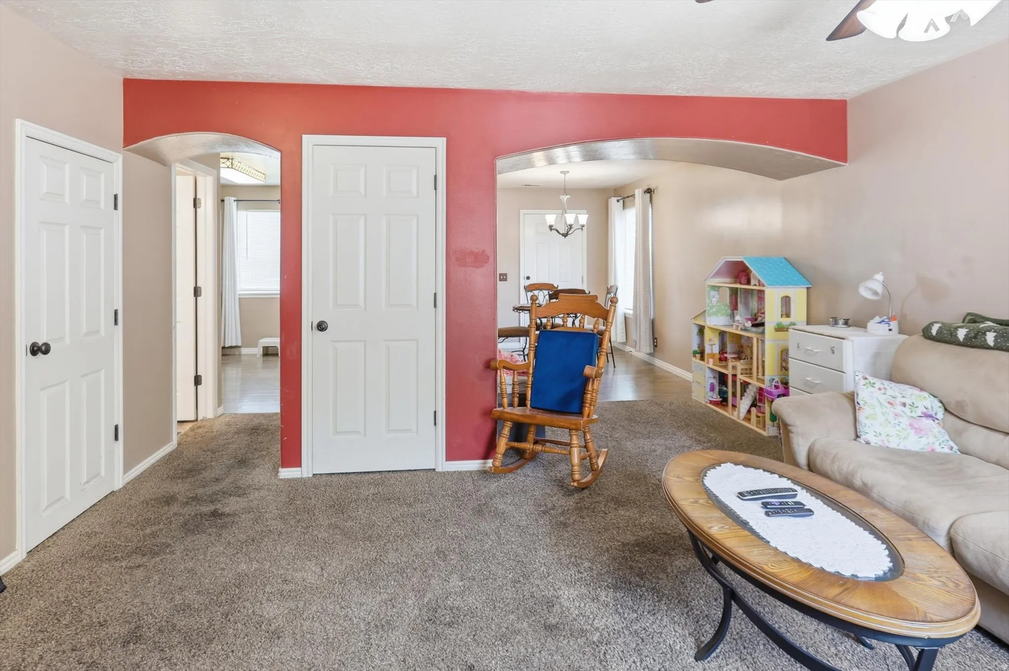 Spacious interior featuring arched doorways, textured ceiling, and five-panel interior doors