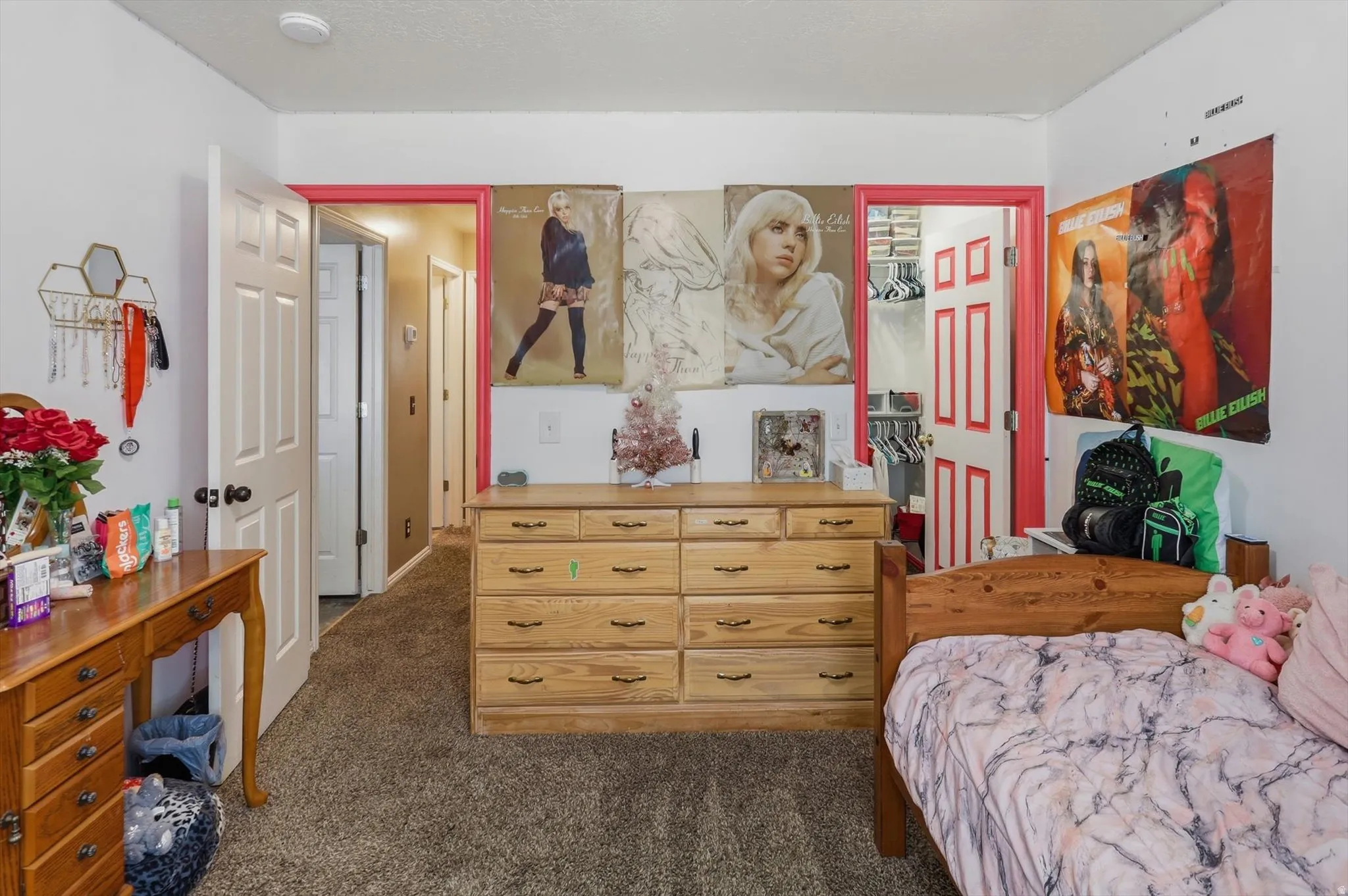 Carpeted room featuring a white paneled door with pink trim, a second white paneled door, and a built-in closet with shelving