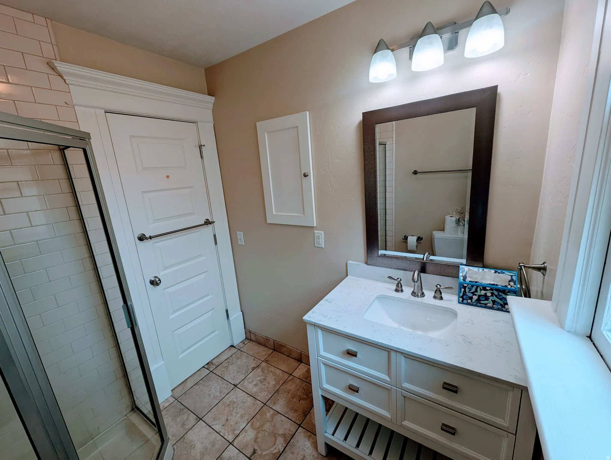 Bathroom featuring a white vanity with a light-toned countertop, an undermount sink, and brushed nickel fixtures