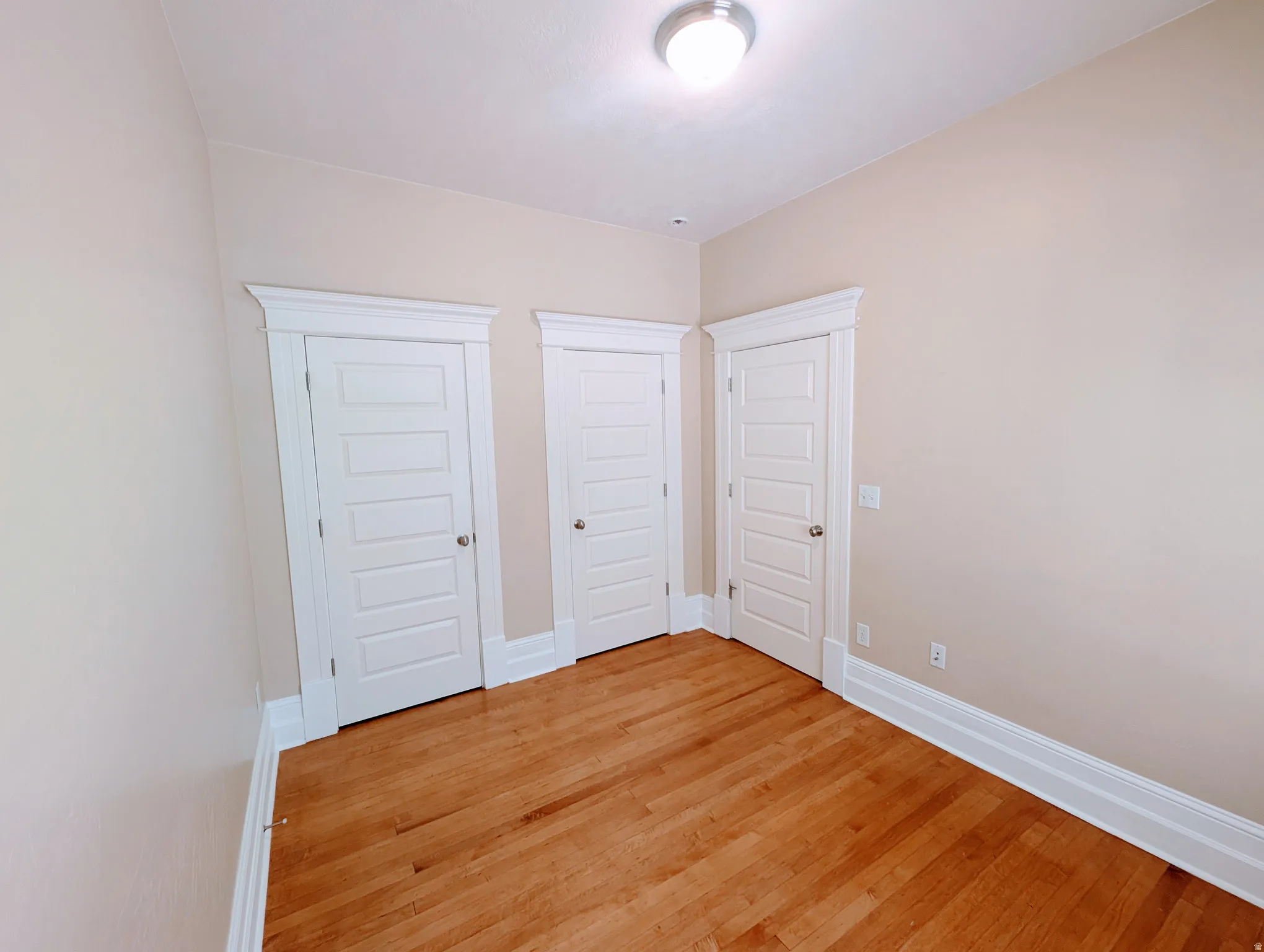 Warm wood-finish flooring complements the neutral wall color