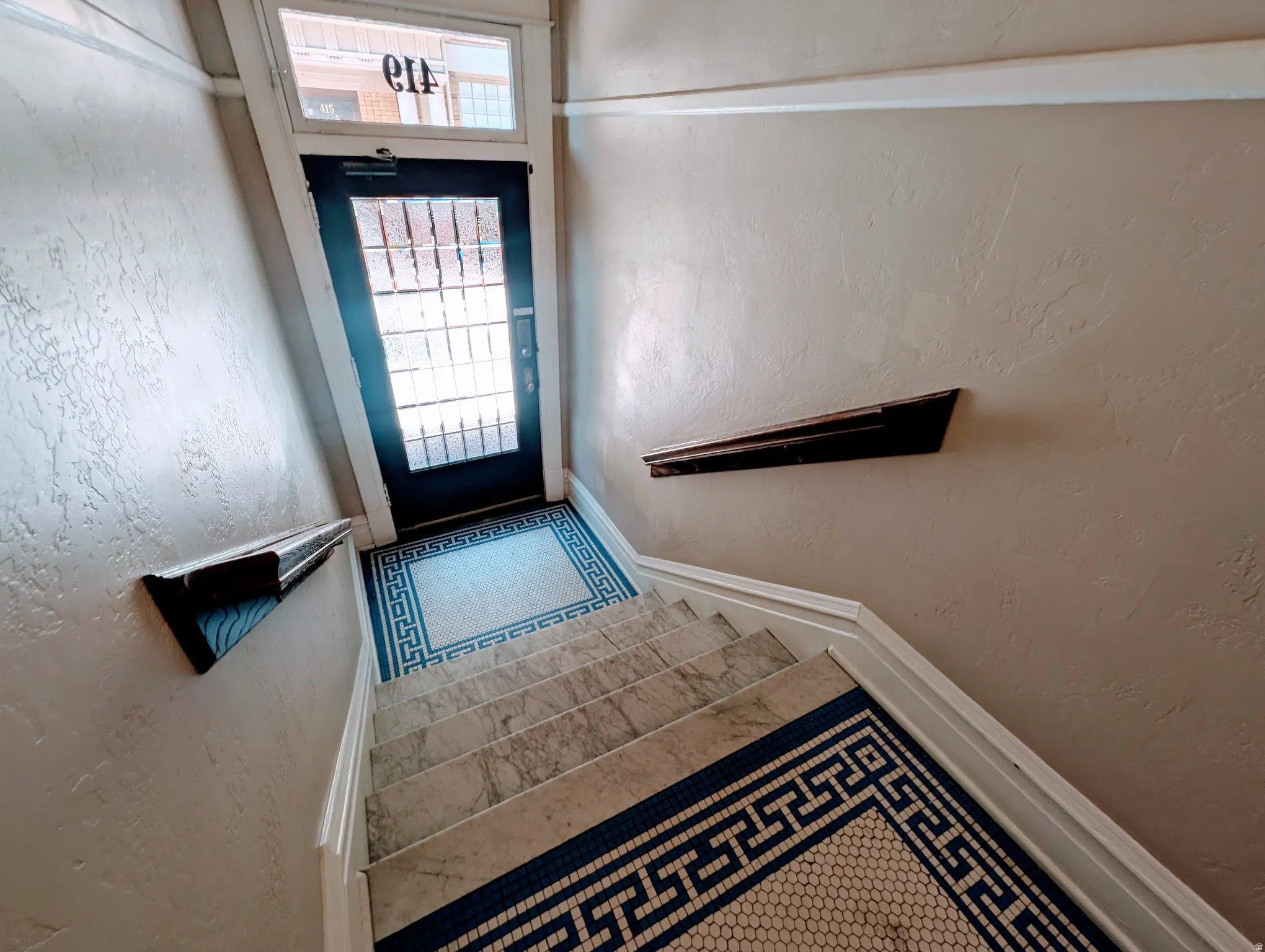 Entryway featuring a black door with glass panels and transom window