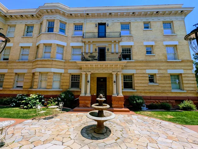 Multi-story brick facade featuring multiple balconies and bay windows